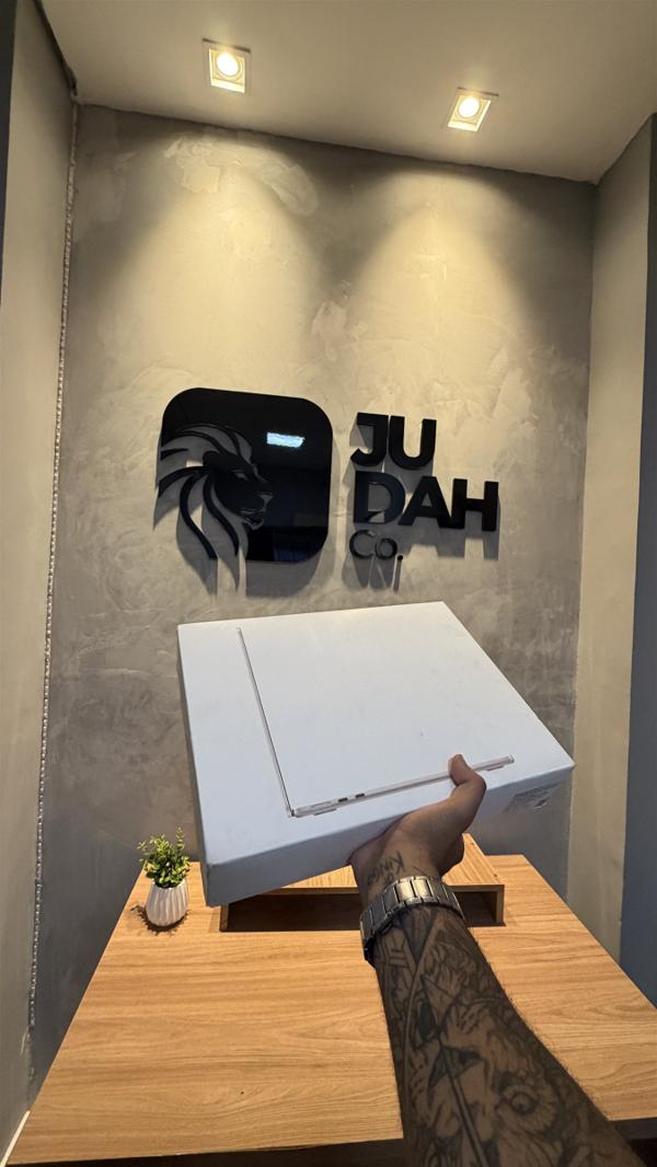MacBook Air lacrado em frente ao logo da Judah