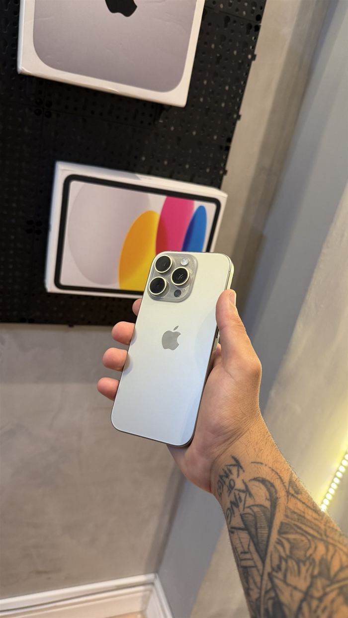 iPhone Pro seminovo na mão, no showroom da Judah